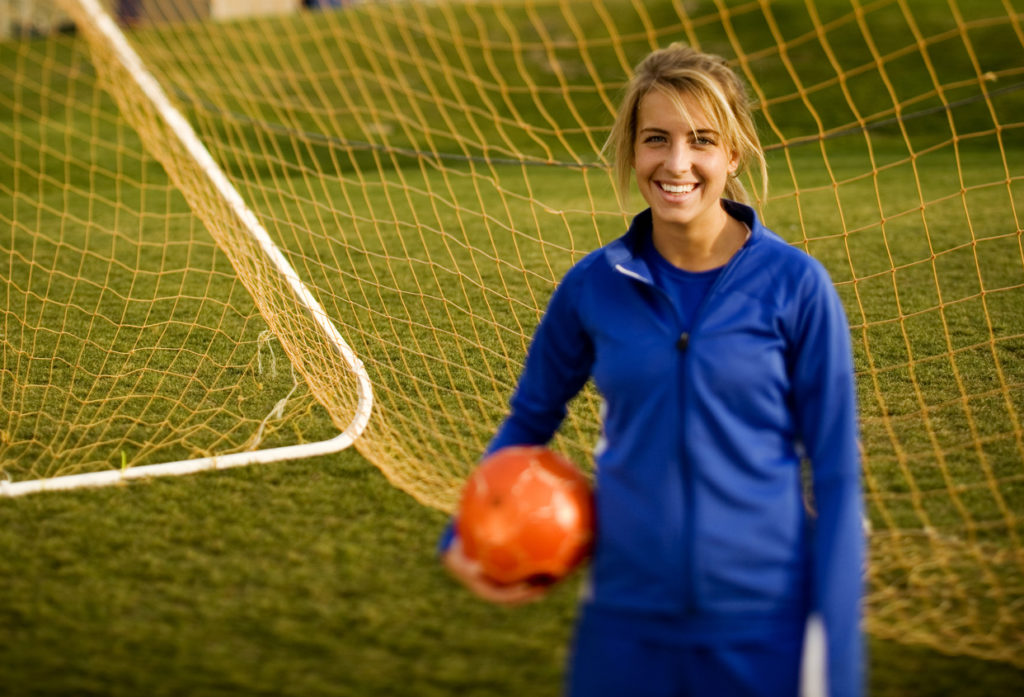 female college soccer player holding soccer ball